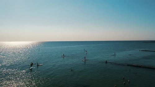 Tourists Floating on SUP Board in Blue Sea