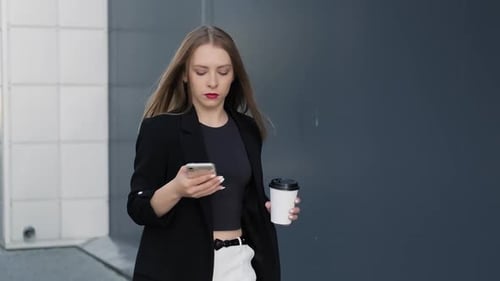Woman Walks with Coffee, Using Mobile Phone in City