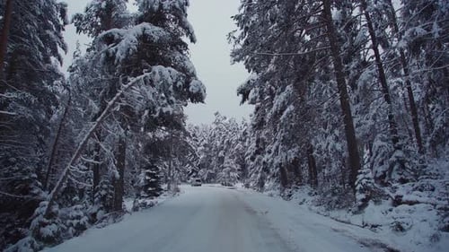 Car driving on snowy and icy road.