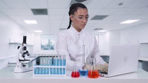 Female Scientist Working in Bright Lab on Laptop