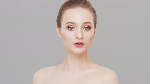 Studio portrait of young, beautiful and natural woman over grey background.