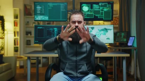 Man Gesturing in front of Computer Monitors