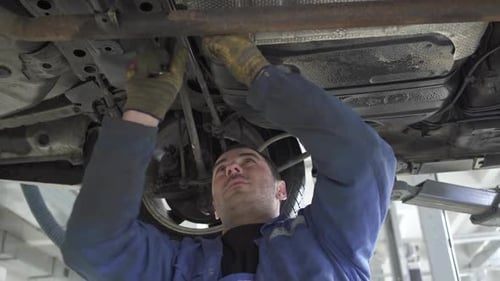 Mechanic Repairs a Car in Garage
