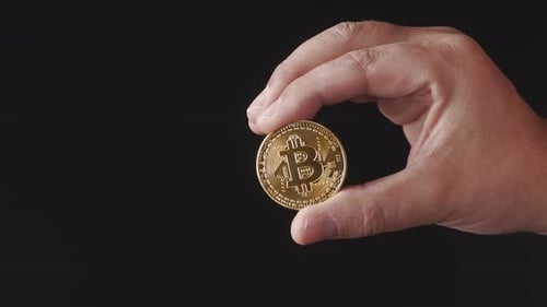 Hand Holding Gold Bitcoin Coin Close Up