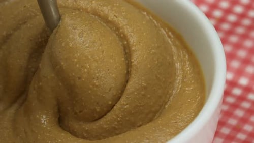 Creamy Peanut Butter Being Stirred in Bowl