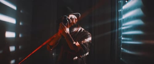 Man Films With Laser Beam in Dark Room