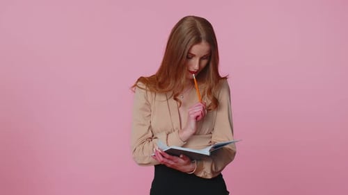 Woman Writes in Notebook on Pink Background