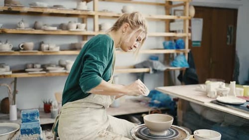 Woman Shaping Clay Bowl at Pottery Wheel