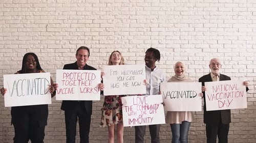 Smiling Group Holding Vaccinated Message Signs