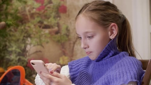 Young Teen Girl Typing Message on Smartphone Screen