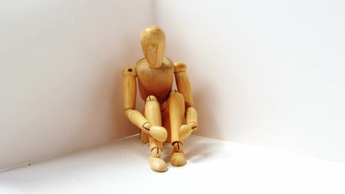 Wooden Mannequin Sitting in Corner