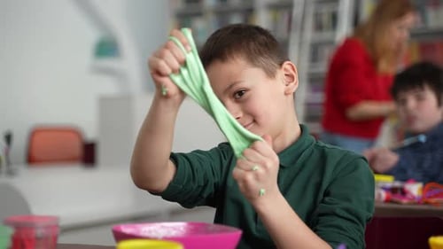 Boy Plays with Slime in a Classroom Setting