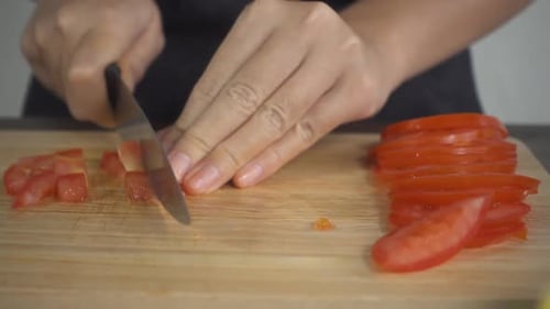 Hands Dicing a Tomato on Cutting Board