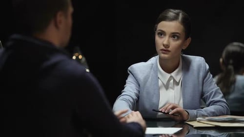 Woman Listens to Man in Handcuffs During Interrogation