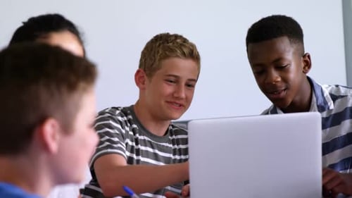 Teens Collaborating on Laptop in Classroom