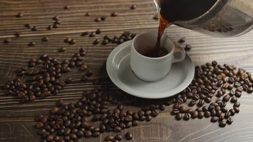 Coffee Poured into Cup with Coffee Beans