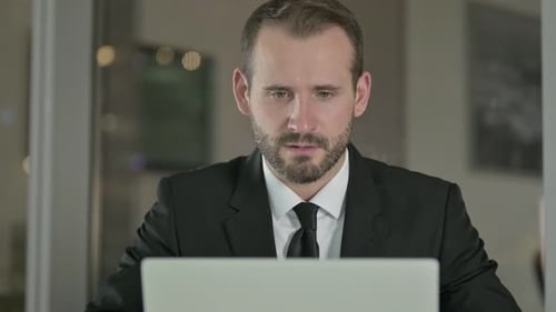 Close Up of Successful Businessman Celebrating While Working at Night