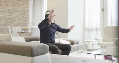 Man Using VR Headset on Couch at Home
