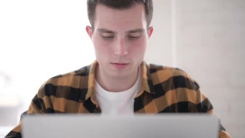 Close Up of Yawning Tired Young Man at Work