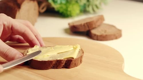 Spreading Butter on a Slice of Rye Bread