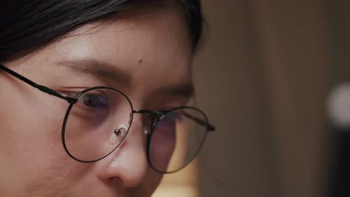 Close up woman wearing glasses using a laptop work from home.