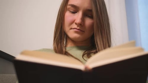 Woman Reading a Book Indoors During the Day
