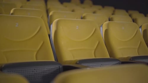Empty Yellow Cinema Chairs with No People on Covid-19 Lockdown. Camera Moves Along Row of