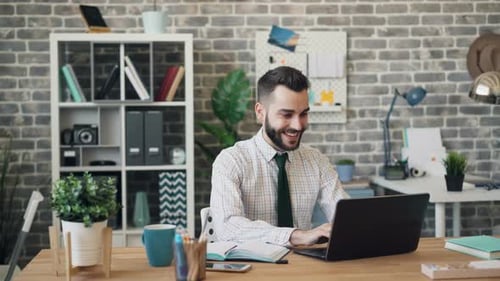 Man Celebrates Success at Office Desk