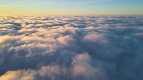 Aerial View From Above at High Altitude of Dense Puffy Cumulus Clouds Flying in Evening