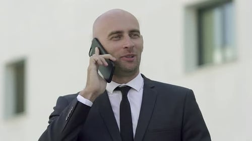 Content Bald Expert Standing on Street and Talking Via Phone