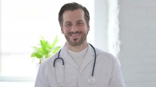Smiling Doctor in White Coat Looks at Camera