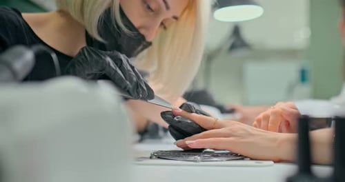 Professional Master Process Nails to Clients in a Modern Salon