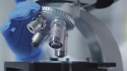 Unrecognizable Scientist Revolving Nosepiece of Microscope