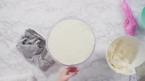 Flat lay. Step by step. Frosting round funfetti cake with white italian buttercream frosting.