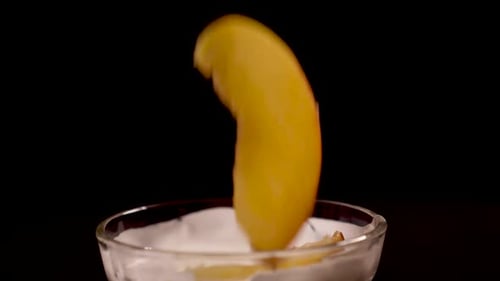 Peach Slices Dropping into Cream Bowl Close Up