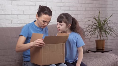 Mother and Child Display Disappointment with Box Contents