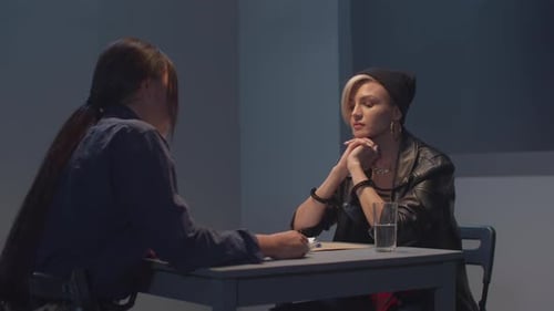 Woman in Handcuffs Being Interrogated by Police