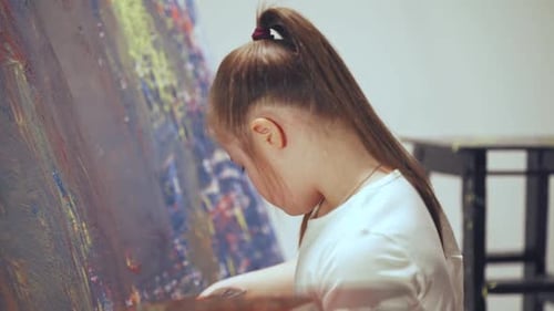Young Girl Painting Colorful Abstract Art in Studio