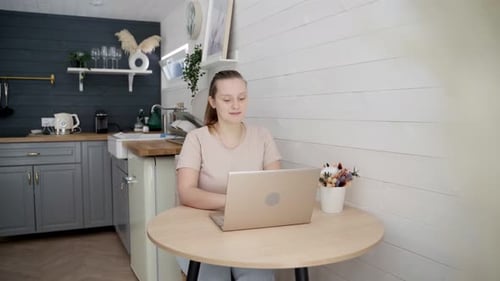 Woman Works On Laptop in Bright Kitchen