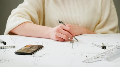 Architect Designer Counting on a Calculator Drawing Plan Blueprint Closeup