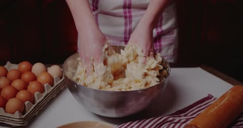 Hands Mixing Dough in a Bowl at Home