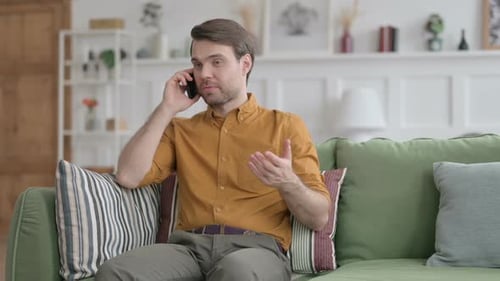 Adult Man Talking on Mobile Phone on Couch