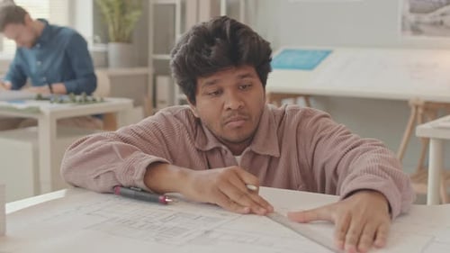 Biracial Architect Drawing Plan in Workshop
