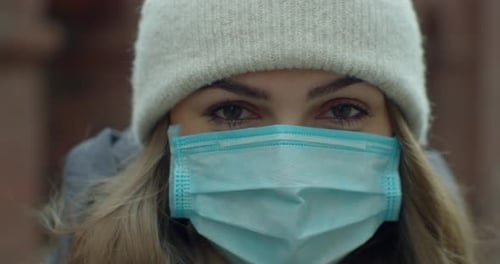 Close Up Portrait of a Beautiful Young Woman in a Hat Wearing Protective Medical Face Mask and
