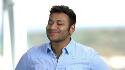 Smiling Young Man Making Faces Indoors