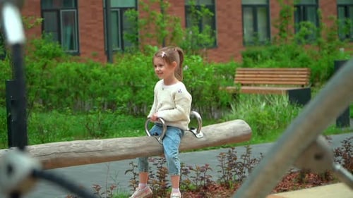 Jeune fille se balançant sur une aire de jeux en plein air