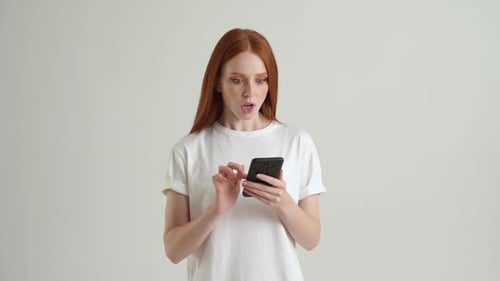 Excited Woman Reacts to News on Smartphone