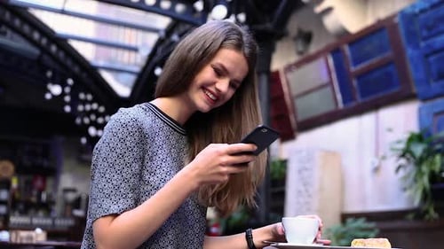 Woman With Phone At Cafe Drinking Coffee