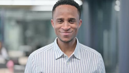 Cheerful Man Smiling at Camera in Office