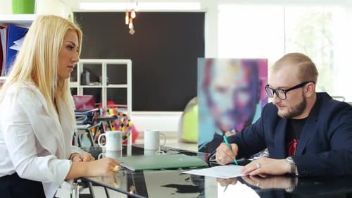Junge Geschäftsleute unterschreiben einen Vertrag.
